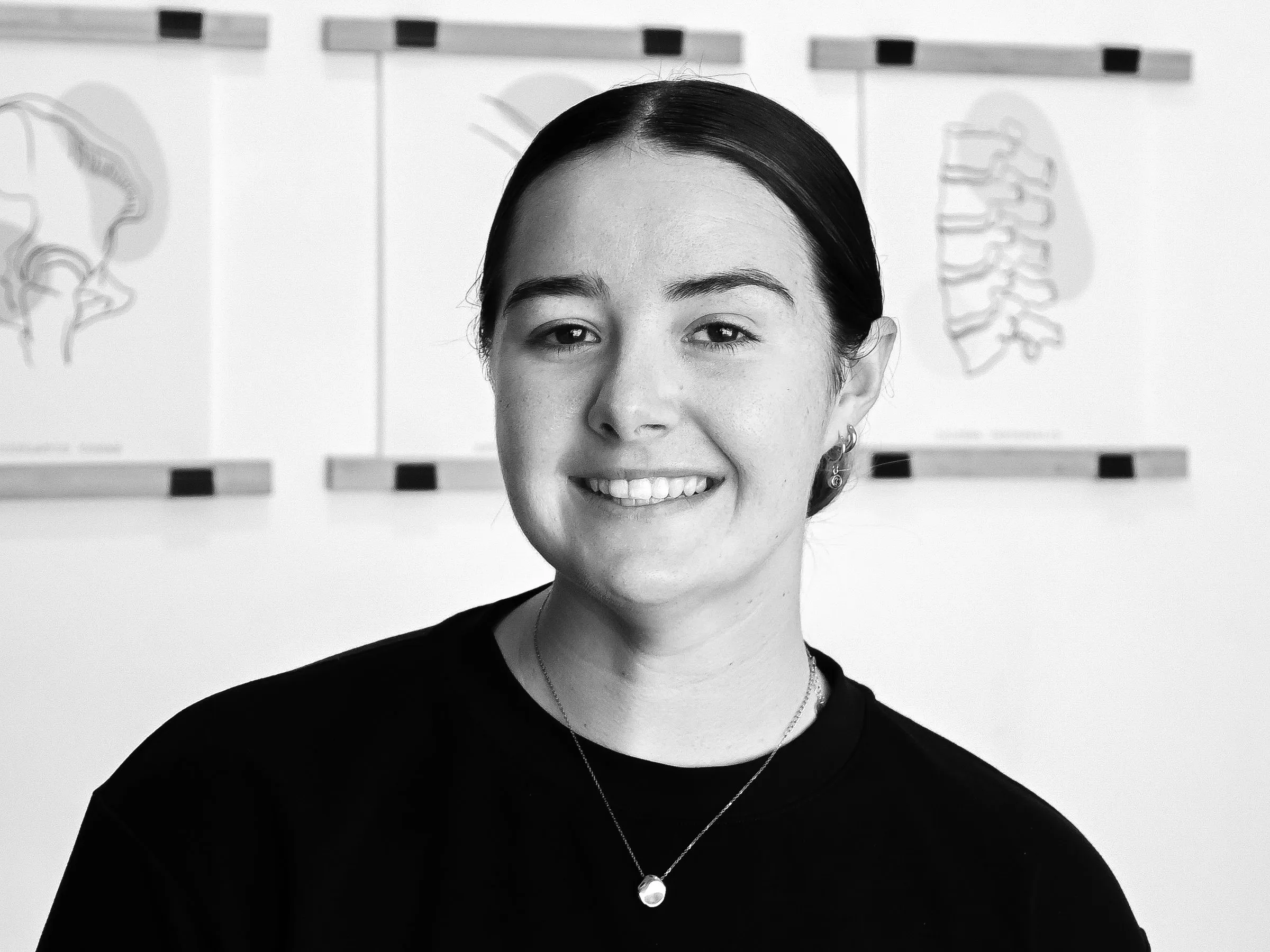 Bianca Petite smiling, in a black T-shirt, in her treatment room.